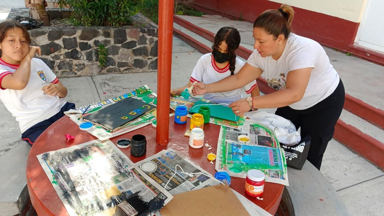 Alumnos pintando carteles